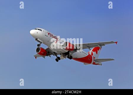 Montréal, Canada - 22 novembre 2022 : Airbus A319-100 Air Canada Rouge, C-FYNS remontant dans les airs après le départ de YUL, Montréal International A. Banque D'Images