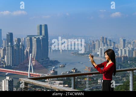 Chongqing. 30 octobre 2023. Un visiteur prend une photo dans la municipalité de Chongqing, dans le sud-ouest de la Chine, le 30 octobre 2023. Située dans le cours supérieur du fleuve Yangtsé, Chongqing s'est continuellement construite en une barrière écologique importante. Crédit : Wang Quanchao/Xinhua/Alamy Live News Banque D'Images