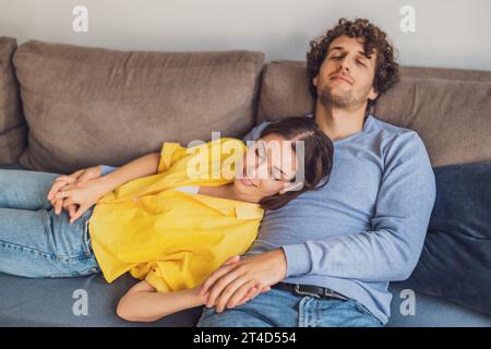 Portrait de jeune couple heureux à la maison. Ils sont relaxants au canapé. Banque D'Images