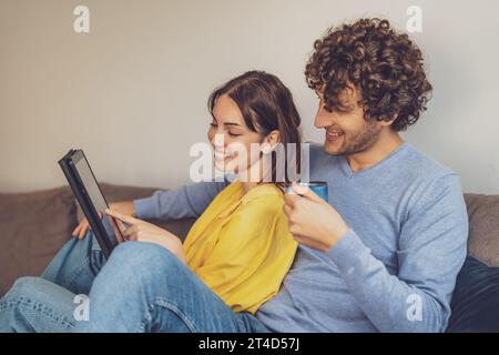 Portrait de jeune couple heureux à la maison. Ils sont relaxants au canapé. Banque D'Images