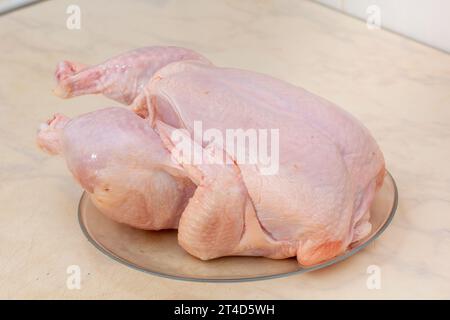 Poulet cru entier sur plaque de verre Banque D'Images
