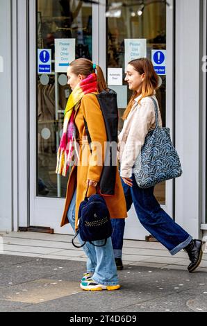 Dundee, Tayside, Écosse, Royaume-Uni. 30 octobre 2023. Météo au Royaume-Uni : un matin d'automne froid mais lumineux avec du soleil occasionnel est idéal pour les habitants de s'aventurer dehors. Dans le centre-ville de Dundee, les femmes à la mode passent la journée à se couvrir du froid tout en profitant du temps automnal. Crédit : Dundee Photographics/Alamy Live News Banque D'Images