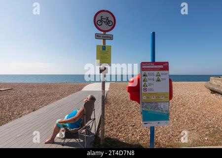 Angleterre, East Sussex, Seaford, femme bronzant sur Seaford Beach Banque D'Images