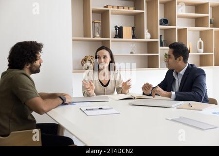 Chef d'entreprise femme confiante parlant à des employés multiethniques Banque D'Images