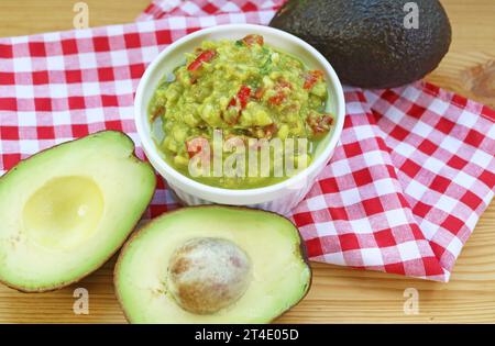 Bol de Guacamole maison avec son ingrédient principal d'avocats frais Banque D'Images