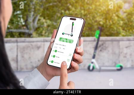 Louer un scooter électrique avec une application, avec téléphone portable. Scooter qui est déverrouillé par l'application en arrière-plan Banque D'Images