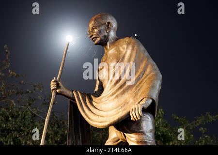 La statue du Mahatma Gandhi située sur la route Belgrave, Leicester. La photo a été prise la nuit avec la lumière de la lune qui brille sur la statue. La statue a été le théâtre de protestations pour enlever la statue. La statue se trouve le long du Golden Mile, la zone où les principales célébrations de Diwali ont lieu chaque année. Banque D'Images