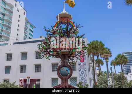 Vue rapprochée d'une statue en forme d'arbre avec serrure, avec en toile de fond de charmants bâtiments sur Collins Avenue à Miami Beach. ÉTATS-UNIS. Banque D'Images
