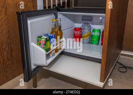 Vue rapprochée du minibar ouvert dans la chambre d'hôtel, approvisionné avec une variété de boissons alcoolisées, de jus de fruits et de sodas pour les clients. Willemstad. Curaçao. Banque D'Images