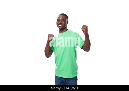 jeune homme africain énergique vêtu d'un t-shirt menthe sur un fond blanc avec espace copie Banque D'Images