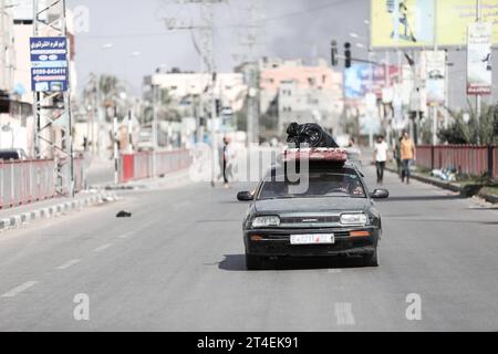 Les Palestiniens conduisent une voiture chargée d’effets personnels tandis que de la fumée gonfle en arrière-plan alors qu’ils fuient le camp de réfugiés de Nuseirat les Palestiniens conduisent une voiture chargée d’effets personnels tandis que de la fumée gonfle en arrière-plan alors qu’ils fuient le camp de réfugiés de Nuseirat, dans le centre de la bande de Gaza, le 30 octobre 2023, au milieu des combats en cours entre Israël et le groupe palestinien Hamas. Photo de Naaman Omar apaimages Nuseirat bande de Gaza territoire palestinien 301023 Nuseirat NAA 0018 Copyright : xapaimagesxNaamanxOmarxxxapaimagesx crédit : Imago/Alamy Live News Banque D'Images