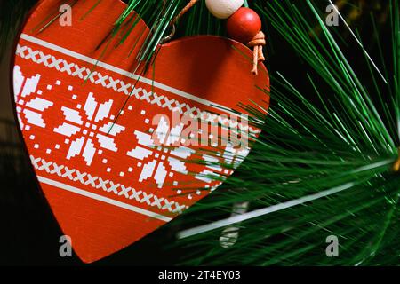 Jouet de Noël sous la forme d'un coeur entouré d'aiguilles vertes d'un arbre de Noël artificiel Banque D'Images