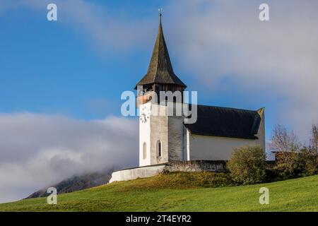 Église Reformierte Kirche dans les Alpes d'automne. Paysage étonnant avec petite chapelle sur prairie ensoleillée à Davos Frauenkirch, Davos, Suisse Banque D'Images