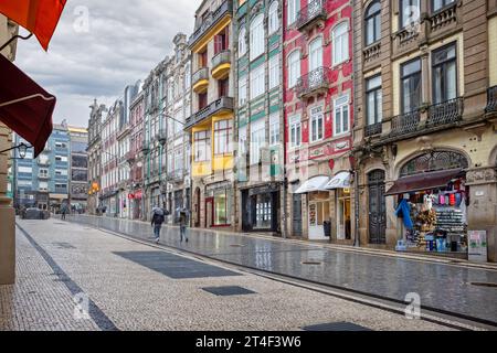 Couple marchant avec des parapluies sous une pluie torrentielle sur Alexander Braga Road à côté du marché Bolhao à Porto, Portugal le 19 octobre 2023 Banque D'Images