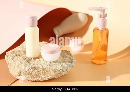 Pierre avec ensemble de produits cosmétiques de voyage sur fond de couleur Banque D'Images