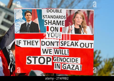 Sur une pancarte : photos du premier ministre canadien Trudeau critiqué pour la position du Canada sur la question. A Montréal, au Canada, une multitude de manifestants se sont unis en solidarité avec les Palestiniens, appelant avec ferveur à un cessez-le-feu urgent à Gaza, le 28 octobre 2023 Banque D'Images