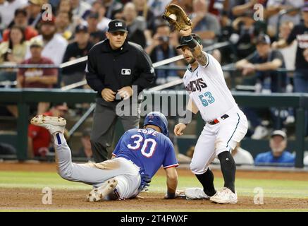 Phoenix, États-Unis. 30 octobre 2023. Le Texas Ranger Nathaniel Lowe replonge à la première place lors d’une tentative de pick-off alors que le premier joueur de base des Diamondbacks de l’Arizona Christian Walker prend le jet du monticule dans la cinquième manche du troisième match de la série mondiale 2023 à Chase Field, à Phoenix, Arizona, le lundi 30 octobre 2023. Photo de John Angelillo/UPI crédit : UPI/Alamy Live News Banque D'Images