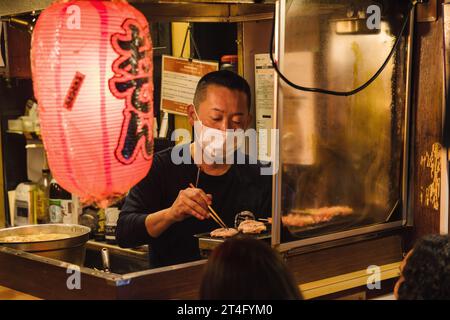 Tokyo, Japon - 11 avril 2023 : scène de nuit dans une cuisine de rue à Tokyo, Japon, avec des personnes non identifiées. Tokyo a une industrie alimentaire célèbre avec beaucoup de Banque D'Images