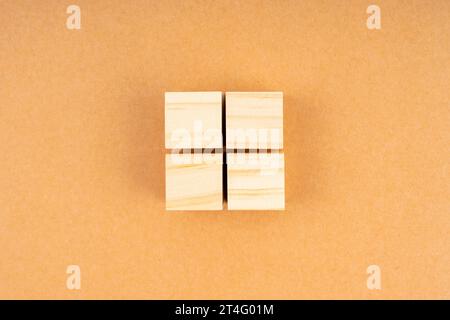 Pyramide de quatre cubes en bois vierges, sur fond brun. Banque D'Images