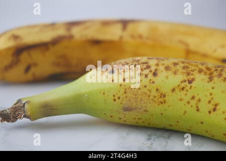 comparer une banane pourrie avec une banane mûre sur fond blanc Banque D'Images