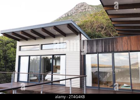 Extérieur de la maison moderne avec balcon en bois et grandes fenêtres Banque D'Images