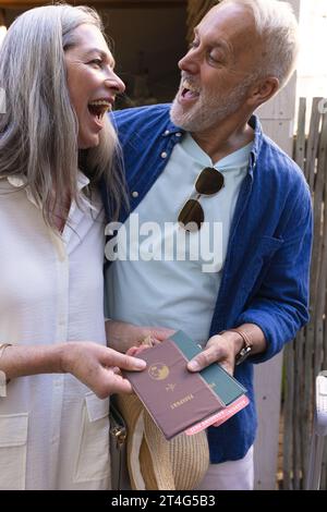 Heureux couple caucasien senior tenant des passeports et souriant Banque D'Images