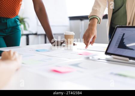 Collègues féminins occupés à la réunion discutant du travail avec des documents sur la table dans le bureau Banque D'Images