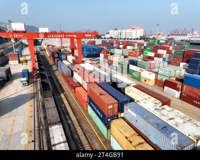 LIANYUNGANG, CHINE - 31 OCTOBRE 2023 - de grandes machines chargent des conteneurs dans un train à la base de coopération logistique Chine-Kazakhstan (Lianyungang) Banque D'Images