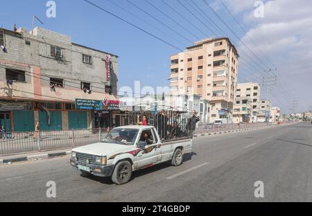 Gaza, Palestine. 30 octobre 2023. Les Palestiniens conduisent une voiture chargée d’effets personnels tandis que de la fumée coule en arrière-plan alors qu’ils fuient le camp de réfugiés de Nuseirat, dans le centre de la bande de Gaza, au milieu des combats en cours entre Israël et le groupe palestinien Hamas. Des milliers de civils, Palestiniens et Israéliens, sont morts depuis le 7 octobre 2023, après que des militants palestiniens du Hamas basés dans la bande de Gaza sont entrés dans le sud d’Israël dans une attaque sans précédent déclenchant une guerre déclarée par Israël au Hamas avec des bombardements de représailles sur Gaza. Crédit : SOPA Images Limited/Alamy Live News Banque D'Images