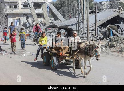 Gaza, Palestine. 30 octobre 2023. Les Palestiniens transportent des biens alors qu’ils fuient le camp de réfugiés de Nuseirat, dans le centre de la bande de Gaza, au milieu des combats qui se poursuivent entre Israël et le groupe palestinien Hamas. Des milliers de civils, Palestiniens et Israéliens, sont morts depuis le 7 octobre 2023, après que des militants palestiniens du Hamas basés dans la bande de Gaza sont entrés dans le sud d’Israël dans une attaque sans précédent déclenchant une guerre déclarée par Israël au Hamas avec des bombardements de représailles sur Gaza. Crédit : SOPA Images Limited/Alamy Live News Banque D'Images