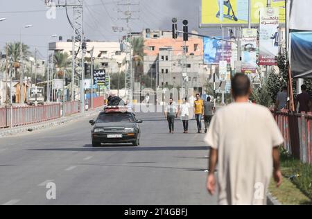 Gaza, Palestine. 30 octobre 2023. Les Palestiniens conduisent une voiture chargée d’effets personnels tandis que de la fumée coule en arrière-plan alors qu’ils fuient le camp de réfugiés de Nuseirat, dans le centre de la bande de Gaza, au milieu des combats en cours entre Israël et le groupe palestinien Hamas. Des milliers de civils, Palestiniens et Israéliens, sont morts depuis le 7 octobre 2023, après que des militants palestiniens du Hamas basés dans la bande de Gaza sont entrés dans le sud d’Israël dans une attaque sans précédent déclenchant une guerre déclarée par Israël au Hamas avec des bombardements de représailles sur Gaza. Crédit : SOPA Images Limited/Alamy Live News Banque D'Images