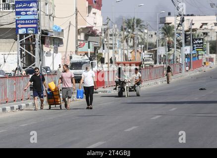 Gaza, Palestine. 30 octobre 2023. Les Palestiniens emportent leurs affaires alors qu’ils fuient le camp de réfugiés de Nuseirat, dans le centre de la bande de Gaza, au milieu des combats qui se poursuivent entre Israël et le groupe palestinien Hamas. Des milliers de civils, Palestiniens et Israéliens, sont morts depuis le 7 octobre 2023, après que des militants palestiniens du Hamas basés dans la bande de Gaza sont entrés dans le sud d’Israël dans une attaque sans précédent déclenchant une guerre déclarée par Israël au Hamas avec des bombardements de représailles sur Gaza. (Photo Ahmed Zakot/SOPA Images/Sipa USA) crédit : SIPA USA/Alamy Live News Banque D'Images