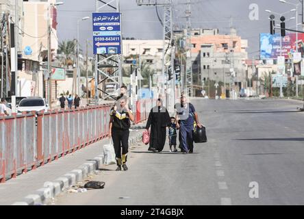 Gaza, Palestine. 30 octobre 2023. Les Palestiniens emportent leurs affaires alors qu’ils fuient le camp de réfugiés de Nuseirat, dans le centre de la bande de Gaza, au milieu des combats qui se poursuivent entre Israël et le groupe palestinien Hamas. Des milliers de civils, Palestiniens et Israéliens, sont morts depuis le 7 octobre 2023, après que des militants palestiniens du Hamas basés dans la bande de Gaza sont entrés dans le sud d’Israël dans une attaque sans précédent déclenchant une guerre déclarée par Israël au Hamas avec des bombardements de représailles sur Gaza. (Photo Ahmed Zakot/SOPA Images/Sipa USA) crédit : SIPA USA/Alamy Live News Banque D'Images