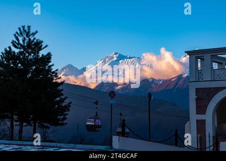La cabine de l'ascenseur aérien avec en toile de fond des montagnes pittoresques couvertes de neige dans la soirée Banque D'Images