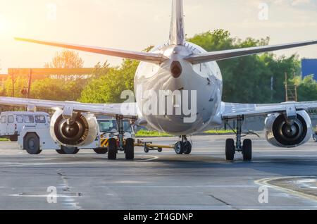 L'avion exécute une opération de refoulement à l'aéroport. Service aérien pour les vols avant le départ le soir au lever du soleil. Banque D'Images