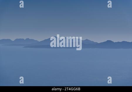 Image bleue de la péninsule de Freycinet dans l'océan calme et la brume UV de midi depuis une longue distance au parc national de Maria Island, Tasmanie, Australie Banque D'Images