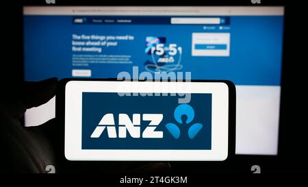 Personne détenant un téléphone portable avec le logo de l'Australie et de la Nouvelle-Zélande Banking Group Limited (ANZ) devant la page Web de l'entreprise. Concentrez-vous sur l'affichage du téléphone. Banque D'Images