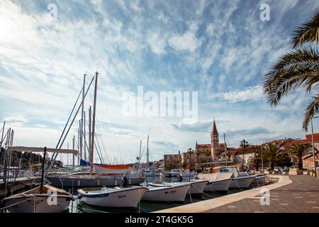 Une vue pittoresque sur un port calme avec plusieurs petits bateaux amarrés au premier plan. Banque D'Images