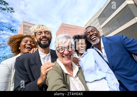 Heureux collègues multiethniques et générationnels prenant un selfie en plein air Banque D'Images