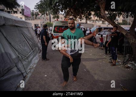 Gaza, Gaza, Palestine. 30 octobre 2023. Un père porte son enfant et le court à l'hôpital après qu'il ait été blessé par le bombardement israélien (crédit image : © Saher Alghorra/ZUMA Press Wire) POUR USAGE ÉDITORIAL SEULEMENT! Non destiné à UN USAGE commercial ! Banque D'Images