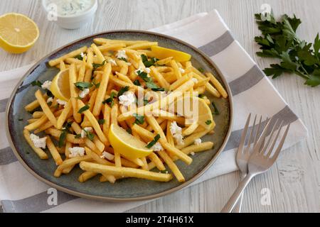 Frites grecques maison avec Feta et Tzatziki sur une assiette, vue latérale. Banque D'Images