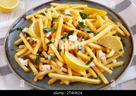 Frites grecques maison avec Feta et Tzatziki sur une assiette, vue latérale. Banque D'Images