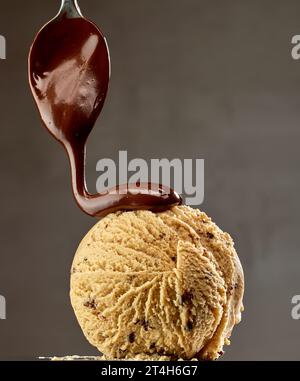 crème glacée caramel avec chocolat fondu sur fond gris foncé Banque D'Images
