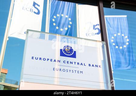 Vue en angle bas du panneau de la Banque centrale européenne à Francfort, en Allemagne, avec des bannières de l'Union européenne en arrière-plan. Banque D'Images