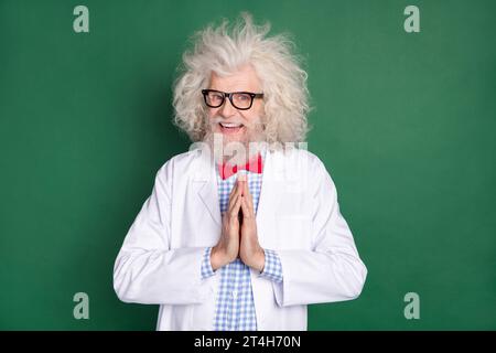 Photo d'heureux souriant funky drôle scientifique fou tenir les mains dans l'excitation d'anticipation isolé sur fond de couleur verte Banque D'Images