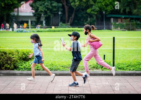 Enfants en train de jouer en courant dans Rizal Park, Ermita, Manille, Philippines. Banque D'Images