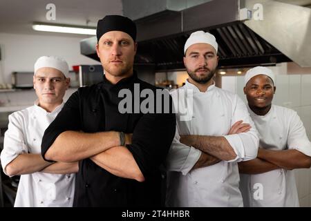 Portrait de divers chefs masculins avec des étudiants debout en toute confiance dans la cuisine à l'école de cuisine Banque D'Images