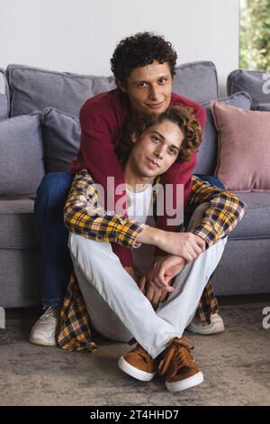 Portrait d'heureux couple masculin gay diversifié embrassant à la maison Banque D'Images