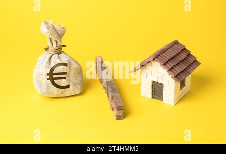 La maison et le sac d'argent euro sont séparés par une barrière. Arrêtez de surchauffer le marché immobilier. L’investissement comme menace de créer une bulle de marché. TH Banque D'Images