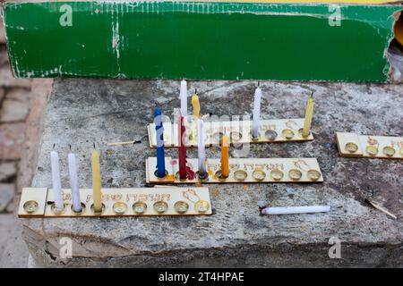 Bougies Hanukkah colorées éteintes et partiellement fondues sur une menorahs portant les mots hébreux « Happy Hanukah » lors de la célébration du Jewi Banque D'Images